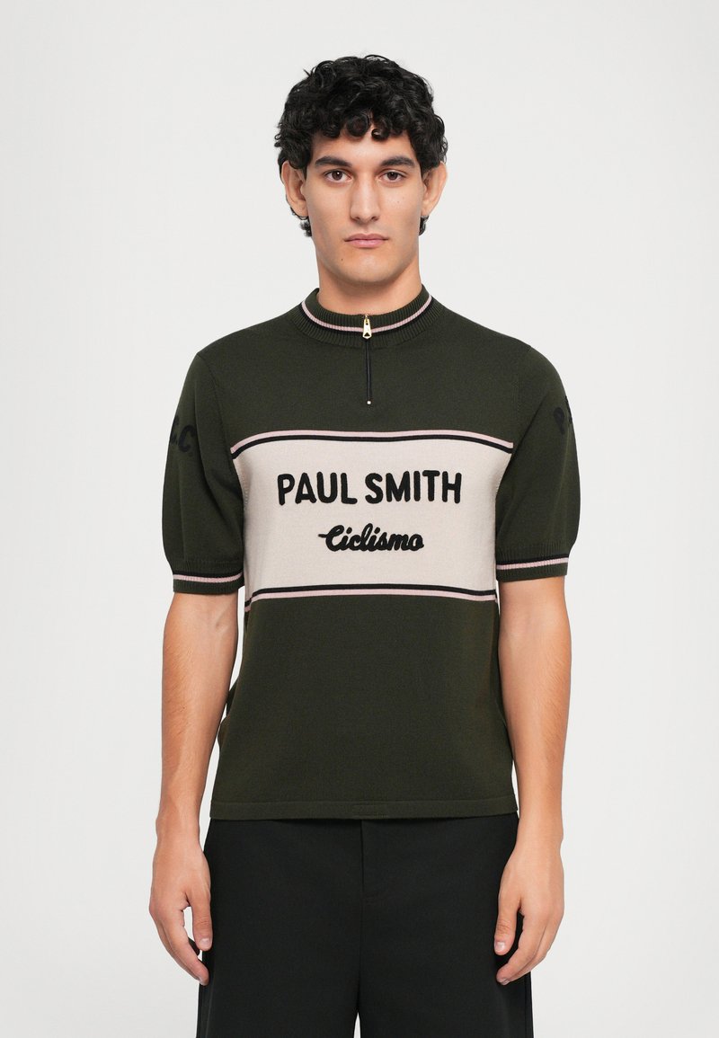 Strick-Polohemd in Dunkelgrün mit kurzen Ärmeln, das beiges horizontales Streifenmuster und den Text "PAUL SMITH Ciclismo" aufweist. Reißverschlussdetail am Hals.