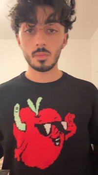 Μαύρο πουλόβερ με μεγάλο γραφικό κόκκινου τσίλι πιπεριού με πράσινες λεπτομέρειες και γυαλιά ηλίου, με υλικό πλεκτό σχέδιο σε όλη την επιφάνεια.