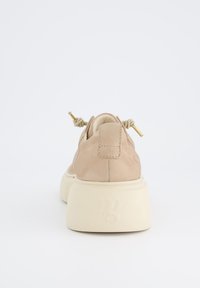 Beige mockaskor med rund tå och chunky krämfärgad sula. Har knutna snörningsdetaljer och präglad logotyp på hälen.