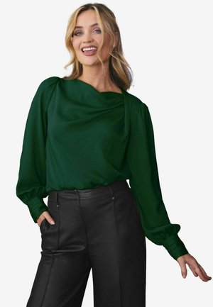 Grüne, drapierte Bluse mit langen Puffärmeln, glatter Textur und weitem Ausschnitt, kombiniert mit hoch taillierten schwarzen Lederhosen.