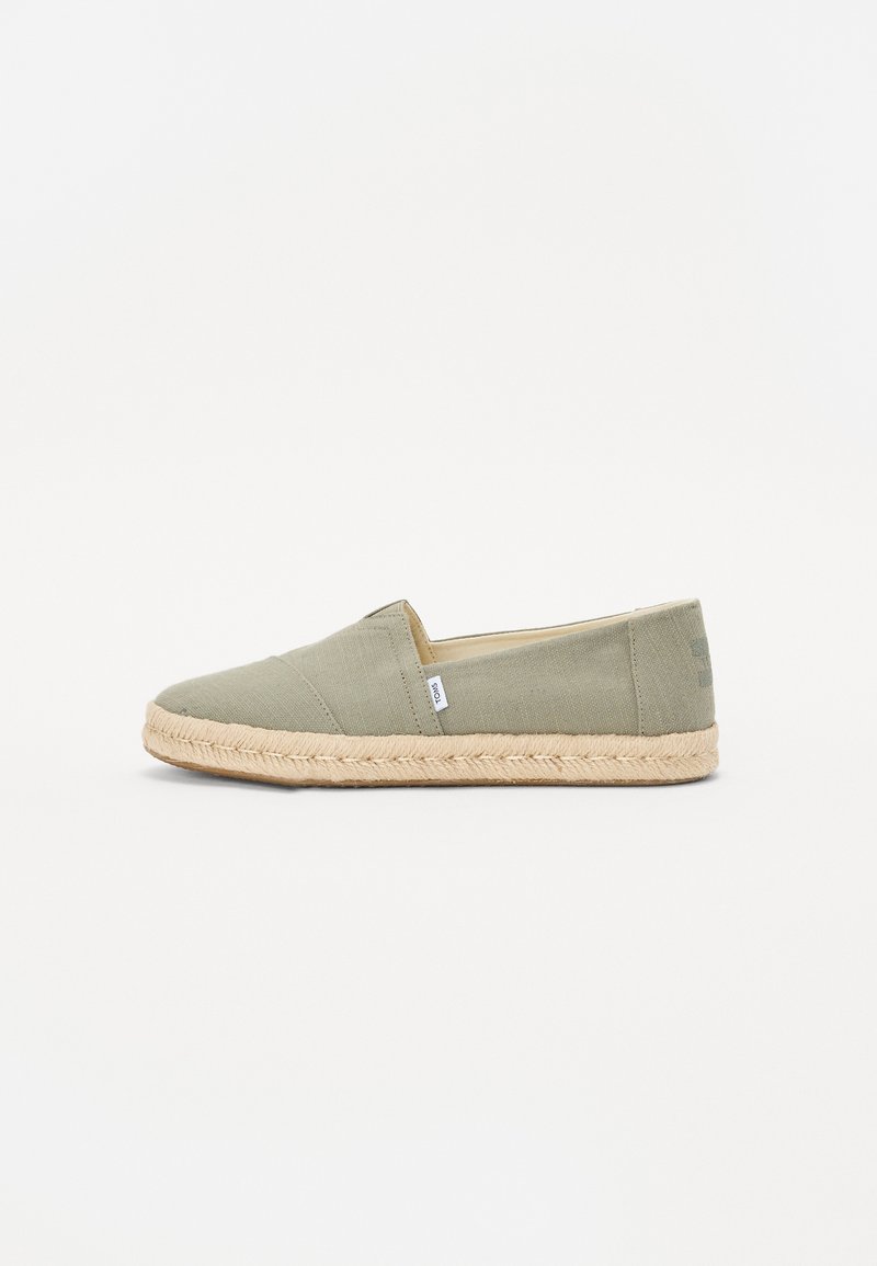 Grüner Canvas-Slipper mit einer Sohle aus Jute-Seil; verfügt über eine abgerundete Zehenpartie und ein kleines Logo-Tag an der Seite. Glatte Textur und minimalistisches Design.