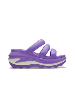 Sandali platform viola con tre ampie cinghie. Realizzati in materiale resistente, presentano una suola spessa e testurizzata e una fascia decorativa bianca.