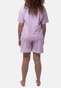 Set di abbigliamento da casa in cotone rosa chiaro, composto da una maglietta a maniche corte e pantaloni corti larghi, con una texture morbida e un design semplice.