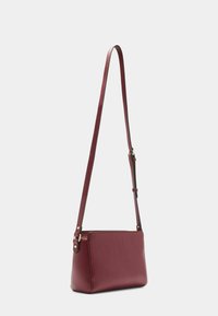 Borsa a tracolla in pelle bordeaux con una finitura testurizzata, forma rettangolare e tracolla regolabile. Presenta accenti in metallo color oro.