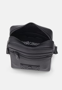 Borsa a spalla in pelle nera con apertura superiore con zip, tasca frontale esterna, logo impresso, texture liscia e rivestimento interno a contrasto.