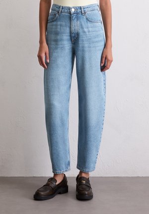 Light blue high-waisted jeans with a straight leg design, faded texture, and five-pocket styling. Paired with brown leather loafers.