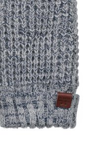 Gebreide grijze beanie met een textuurpatroon, voorzien van een geribde rand en een leren label in bruin aan de zijkant.