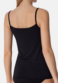 Zwarte geribde tanktop met smalle bandjes, met een aansluitend ontwerp en een rechte zoom op de taille. Zachte textuur, minimale details.