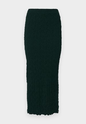 Tume roheline, tekstuuriga, põlveliigini ulatuv seelik, millel on vormitud siluett ja laineline äär. Materjal tundub kortsuline ja sileda pinnaga.