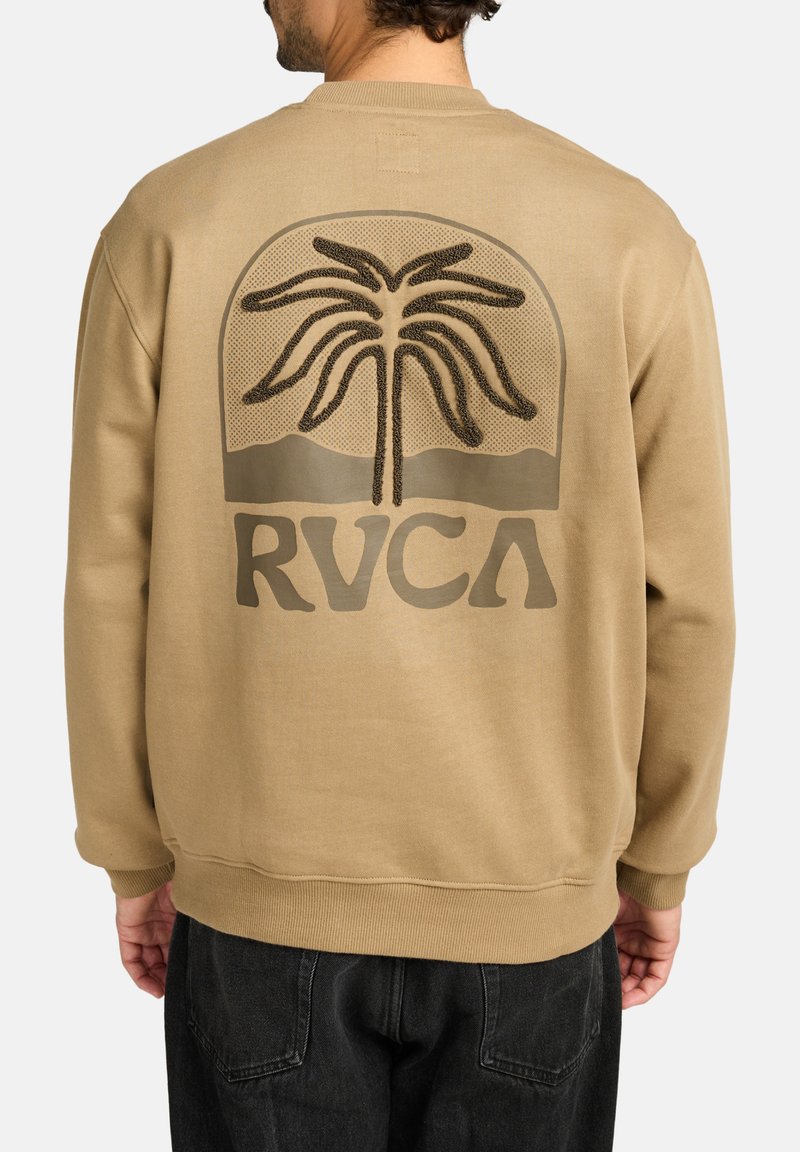 Sweatshirt beige arboré d'un grand motif texturé représentant un palmier et du logo "RVCA" au dos. Les poignets et l'ourlet côtelés ajoutent de la structure.