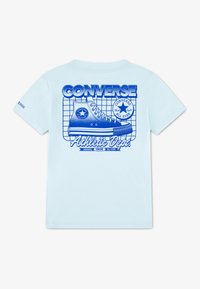 Ανοιχτό μπλε βαμβακερό μπλουζάκι με μπλε σχέδιο παπουτσιού Converse και κείμενο σε μοτίβο με πλέγμα· στρογγυλή λαιμόκοψη και κοντά μανίκια.