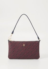 Petit sac à main rectangulaire bordeaux avec motif géométrique foncé, fermeture éclair dorée, emblème logo, et bandoulière amovible bleu marine.