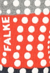 Chaussette à motifs rouges et gris avec de grands pois blancs, fabriquée en tissu tricoté avec des surfaces texturées et portant le nom de la marque "FALKE."