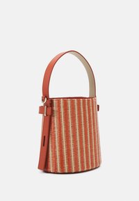 Mała torba typu bucket z pomarańczowo-beżowym wzorem plecionym, wyposażona w gładką pomarańczową skórzaną rączkę oraz regulowany pasek na białym tle.
