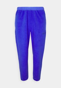 Lila fleece-joggingbyxor med elastisk midja och sidofickor. Har minimal svart branding på vänster lår.