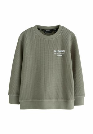 Olivgrön stickad sweatshirt med rund halsringning, långa ärmar och ribbade muddarna. Har en vit broderad logotyp på bröstet.