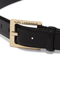 Fekete bőr öv, arany fémcsattal, amelyen a "KARL LAGERFELD" felirat található, több méretállító lyukkal.