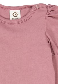Pink baby onesie with rounded neckline, textured fabric, gathered puff sleeves, and a snap fastener at the shoulder. Brand label visible inside.