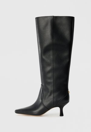 Stivale alto in pelle nera con punta affusolata, design elegante e tacco a cono di 3 pollici. Caratterizzato da un accento dorato sul retro.