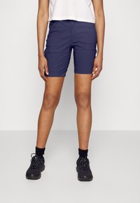 Marinblå shorts i lättviktsmaterial med sidofickor, skräddarsydd passform och sydda detaljer. Kombinerat med svarta sneakers.