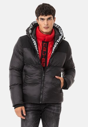 Schwarze Daunenjacke mit einer roten isolierten Innenschicht, ausgestattet mit einer Logo-betonten Kapuze, Reißverschluss, Fronttaschen und gerippten Ärmelbündchen.