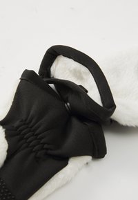 Gant noir et blanc avec doublure en fourrure douce et élastique. Présente un extérieur en tissu lisse avec une texture douce et de subtils détails de couture.