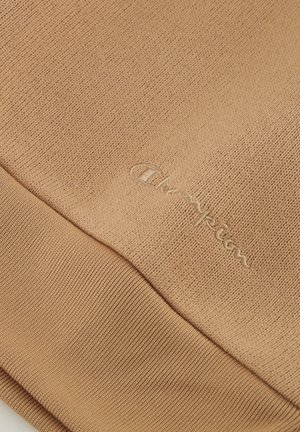 Bruine katoen trui van stof met een gestructureerde brei en geribbelde onderkant. Bevat een subtiele geborduurde "Champion" logo in bijpassend garen.