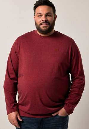 Camisa de manga larga color burdeos en una tela suave y texturizada con cuello redondo. Presenta un logotipo sutil en el pecho y un diseño de ajuste relajado.