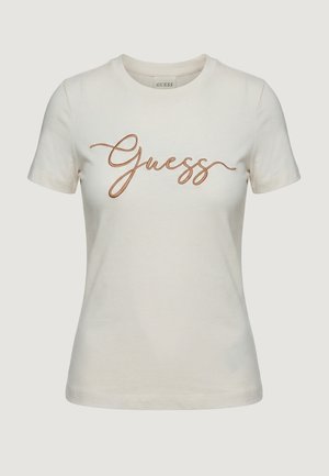 T-shirt crema a maniche corte con scollo rotondo e logo "Guess" ricamato in corsivo color rame sul petto.