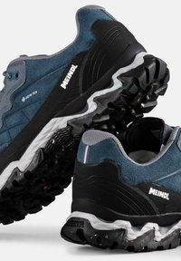 Męskie buty trekkingowe z górną częścią wykonaną z niebiesko-szarej zamszowej skóry, czarnymi akcentami i teksturowaną gumową podeszwą. Zawierają logo GORE-TEX oraz charakterystyczny wzór bieżnika.