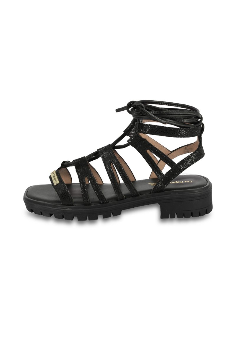 Sandalias negras de estilo gladiador con un acabado texturizado, múltiples correas, diseño con cordones y una suela de goma gruesa para tracción.