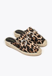 Espadrile s leopard uzorkom bez kopčanja, s tkanim jutenim potplatom, ukrašene prozirnim kristalnim akcentima duž remena. Crno-bež shema boja.