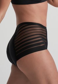 Pantaloni corti neri a vita alta con un pannello trasparente a righe sui lati, caratterizzati da una texture liscia e una cintura elastica.