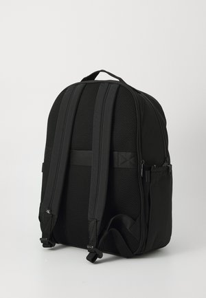 Fekete hátizsák, texturált anyagból készült, párnázott hálós vállpántokkal, vállfogóval és oldalsó zsebekkel a tároláshoz. Simán záródó cipzárral.