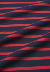 Kék anyag vízszintes piros csíkokkal, sima textúra, enyhe fényesség, és ráncok, amelyek dimenziót adnak. A csíkok egyenletesen elhelyezkednek.