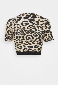 Beżowo-czarny krótki top w panterkę, z krótkimi rękawami i czarną taśmą na dole z napisem. Tkanina o fakturze z różnorodnymi plamkami.