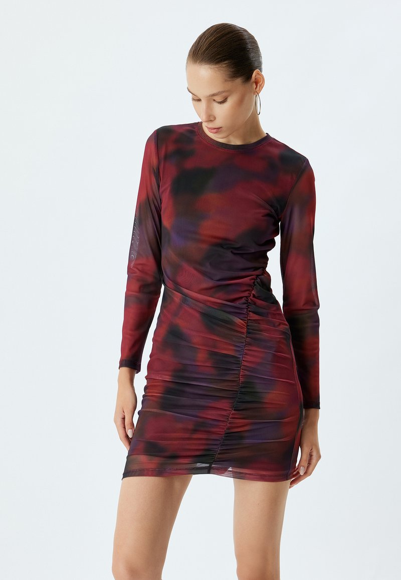 Langsleeve jurk in een abstract patroon van rood en paars, geplooid ontwerp, getailleerde silhout, semi-transparante stof, knielange zoom.