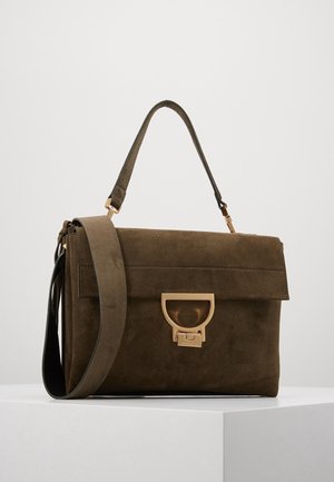 Braune Wildleder-Handtasche mit einem oberen Griff und abnehmbarem Schulterriemen, mit einem goldfarbenen Verschluss auf einer einfarbigen weißen Oberfläche.