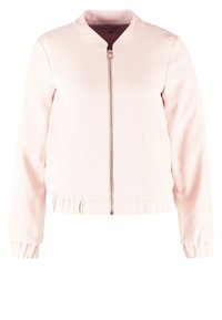 Veste bomber rose clair avec fermeture éclair à l'avant et poignets élastiques, affichée sur un fond blanc.