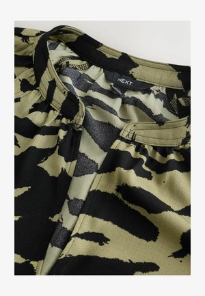 Fekete és olívazöld blúz tigrissávos mintával, könnyű anyagból, kerek nyakkivágással és gyűjtött díszítéssel.