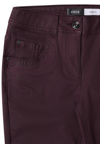 Bordeaux broek met een gladde textuur, vijf zakken en zwarte knoop hardware. Kenmerkt zich door een gestikte tailleband en zijnaad voor structuur.