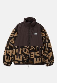 Rudos ir smėlio spalvos zip-up striukė su pūkine tekstūra, geometriniais raštais ant rankovių, aukštu apykakle ir ženklu krūtinėje.