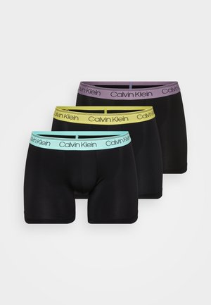 Kolm paari musti bokserpükse kontrastsete elastsete vöödega mündiväärsusrohelises, kollases ja lavendli värvis, millel on "Calvin Klein" logo.