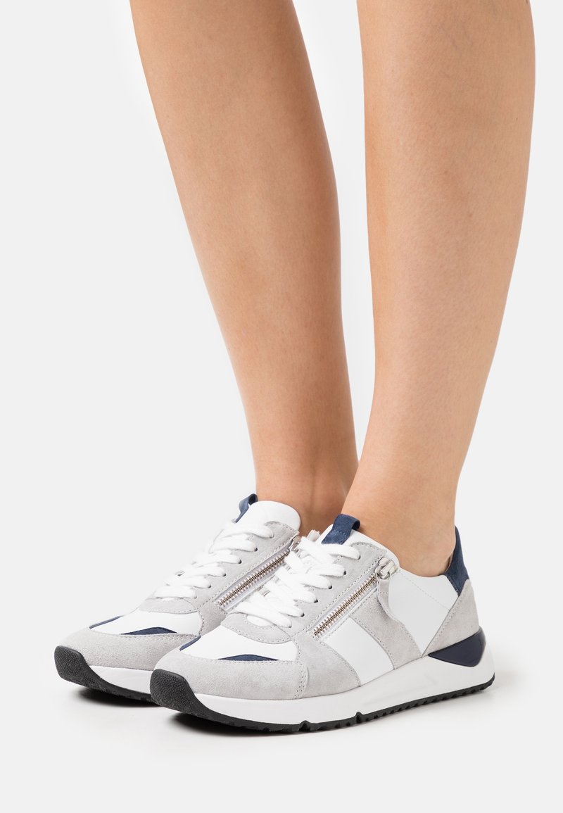 Atletiska sneakers i vitt, grått mocka och marina accenter; har snörning fram och sidodragkedjedetalj. Tjock svart gummisula.