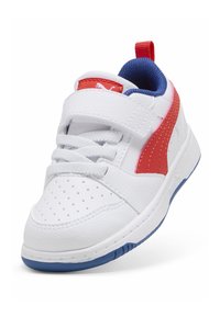 La zapatilla cuenta con una parte superior de cuero blanco, una franja sintética roja, forro interior azul, puntera perforada y una suela plana de caucho.