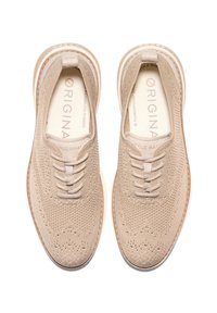 Beige Strick-Sneaker mit elastischen Schnürsenkeln, strukturiertem Obermaterial und einer weißen Gummisohle. Logo auf der Innensohle aufgedruckt. Runde Zehenform.