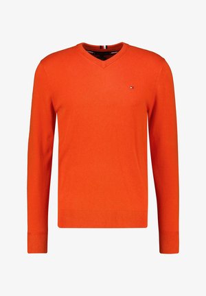 Maglione arancione a scollo a V in tessuto a maglia, con maniche lunghe e orlo a coste. Piccolo dettaglio logo sul petto. Tessitura uniforme su tutta la superficie.
