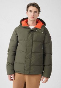 Chaqueta acolchada verde oliva con interior naranja, capucha adjunta, cremalleras laterales y un acabado texturizado. Acentuada con un logotipo en la manga.