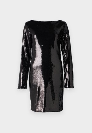 Abito nero a maniche lunghe rivestito di grandi paillettes, con scollo a barca e silhouette aderente, che riflette la luce in diverse sfumature.