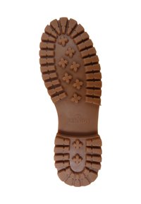 Suela de zapato de goma marrón con un patrón texturizado de botones redondeados y formas de cruz, que presenta el logo "Sebago" cerca del talón.
